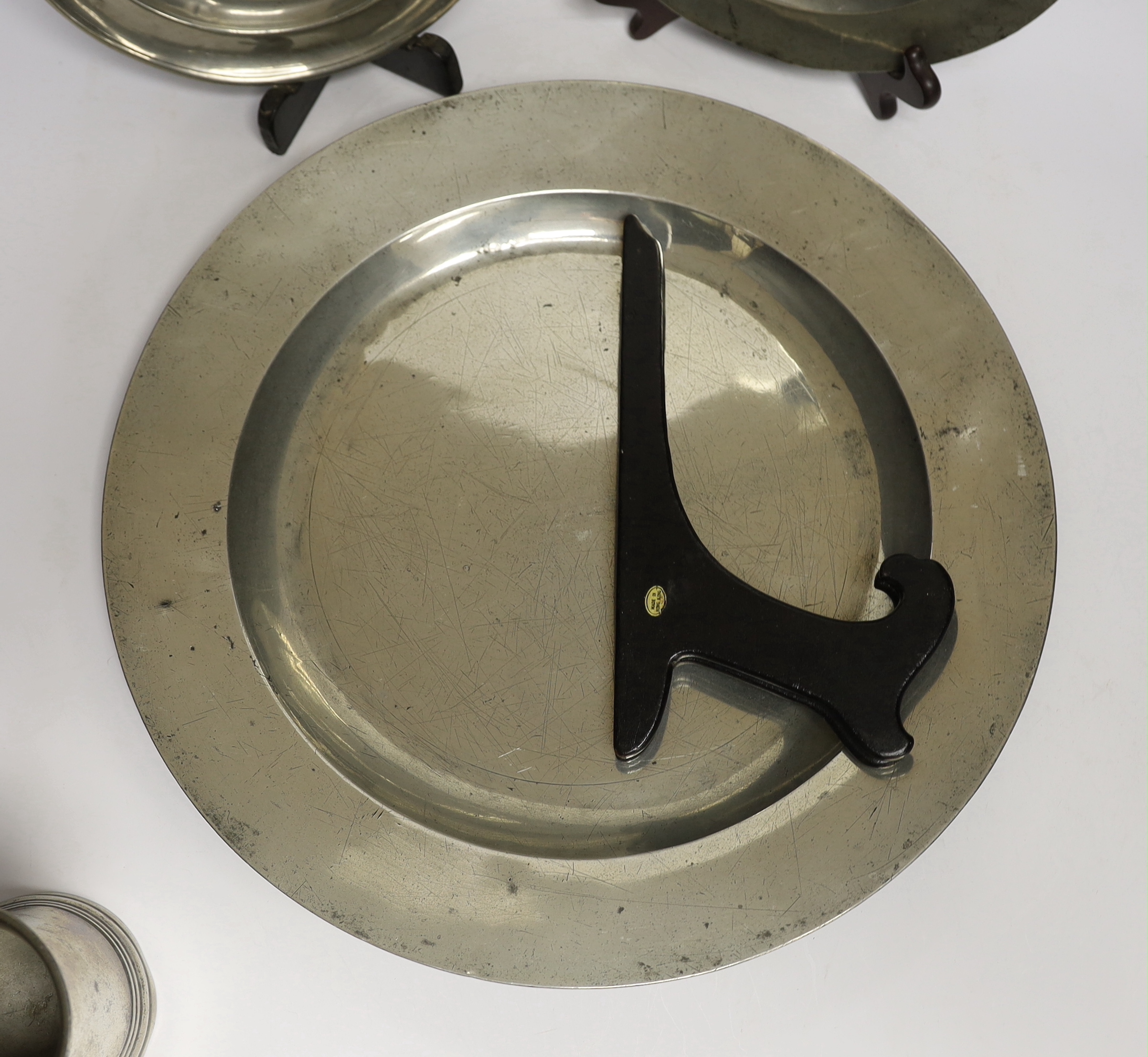 Four 18th century and later pewterware items including a charger, 41.5cm diameter, two plates, and a mug